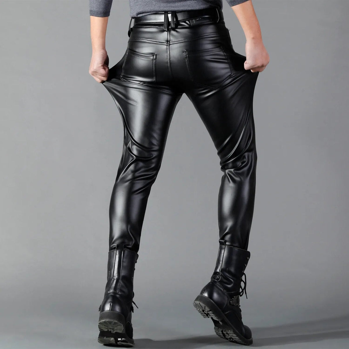 Man wearing black faux leather skinny trousers, pulling pockets, rear view | Chaps London