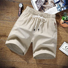Beige cotton drawstring shorts with elastic waist, laid flat on wood surface | Chaps London