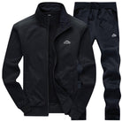 Black zip-up tracksuit jacket and matching pants, laid flat, sports logo | Chaps London