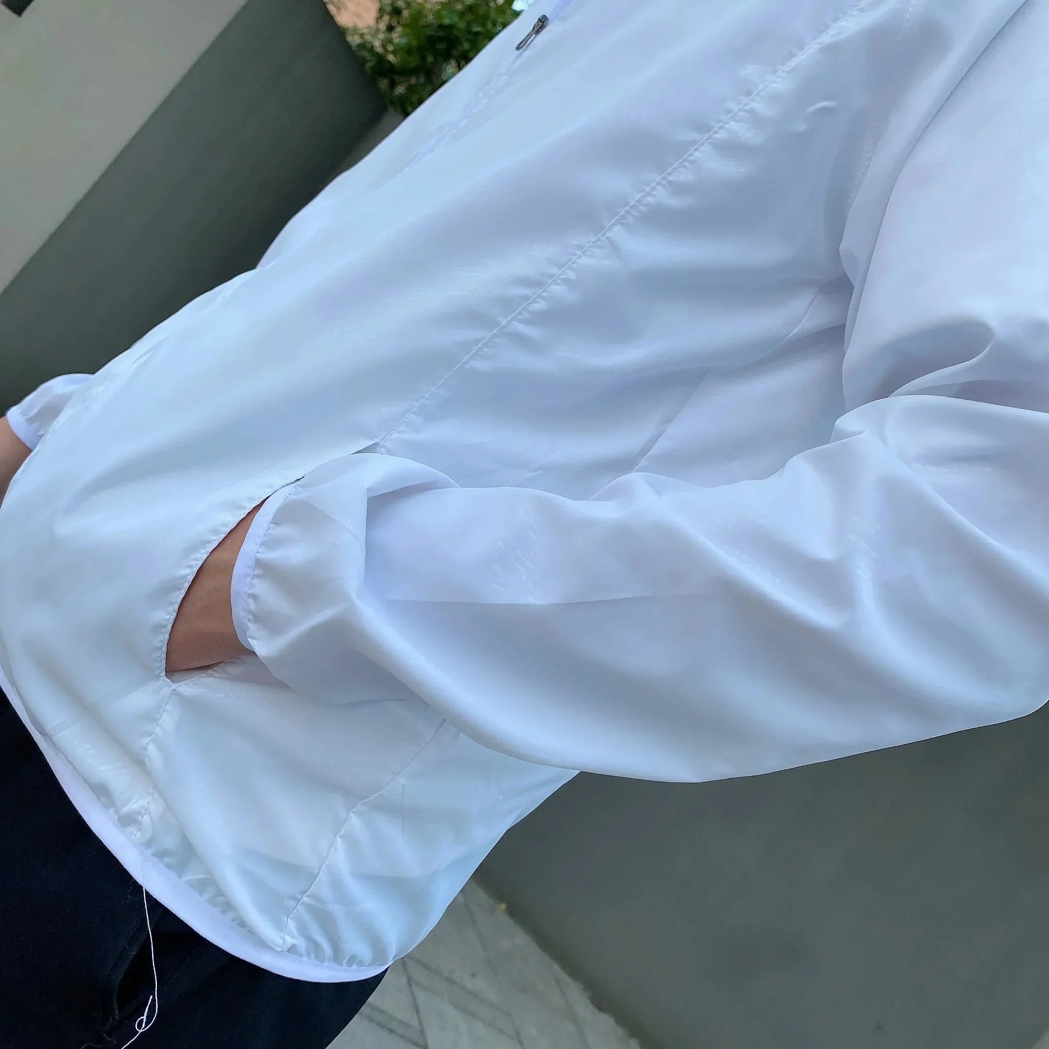White lightweight jacket with hand pocket, worn by a person outdoors | Chaps London