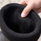 Feature panel showing a black PVC rain boot with a black fleece cuff on a wet surface, with four detail close-ups and English feature callouts, close-up view