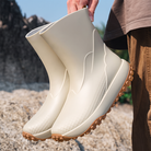 Cream rubber boots with tread sole, held by hand outdoors | Chaps London