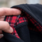 Black hoodie with red plaid lining, hood detail close-up, worn by person | Chaps London