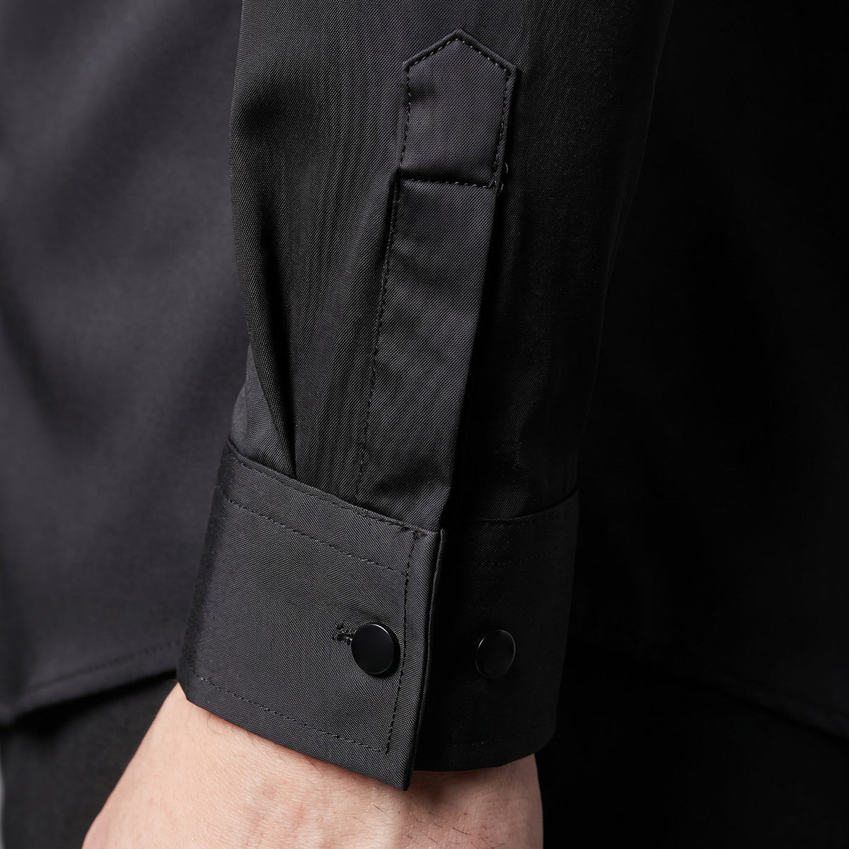 Black long sleeve shirt cuff with button detail, worn by person | Chaps London