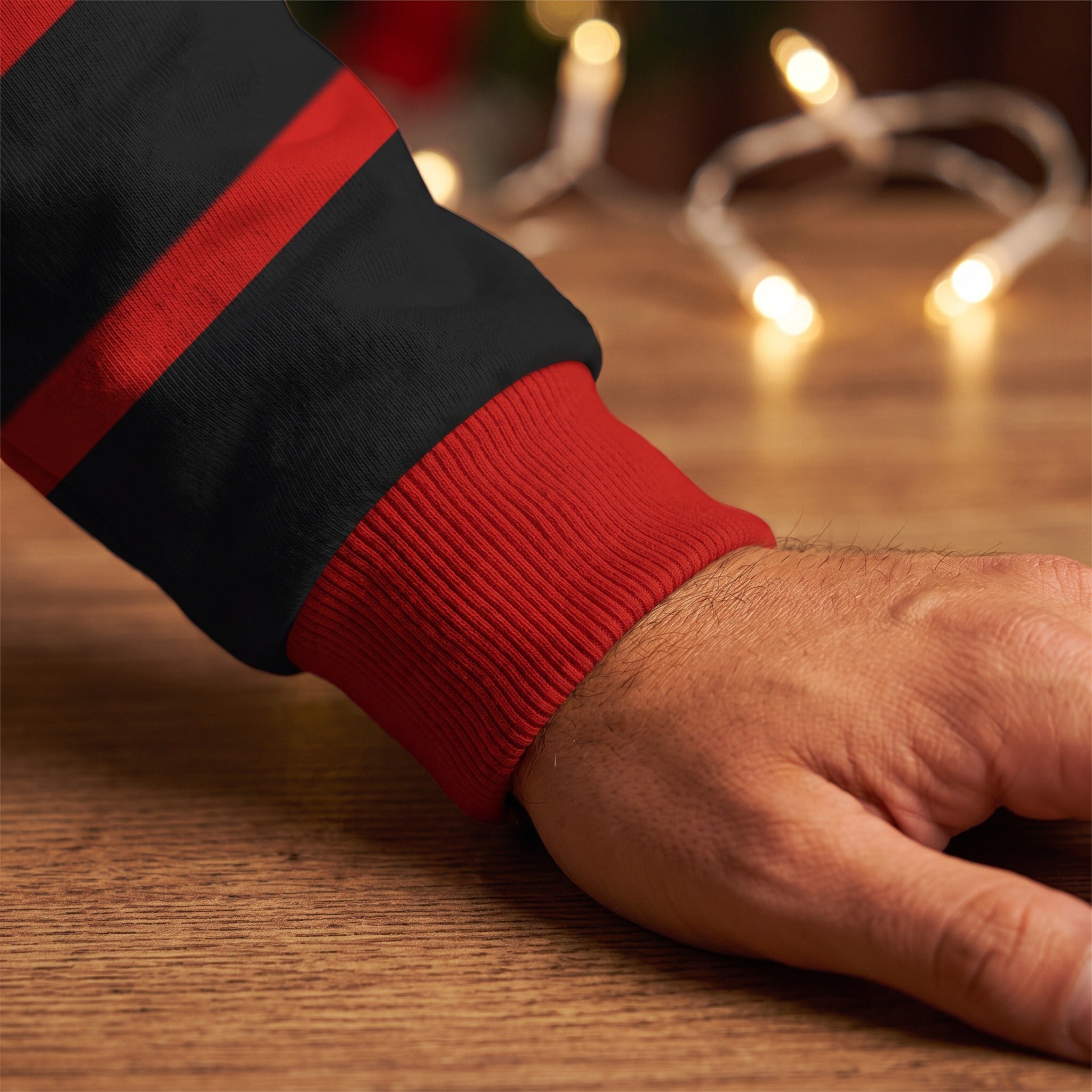 Black and red striped sweatshirt cuff worn on wrist near lights | Chaps London