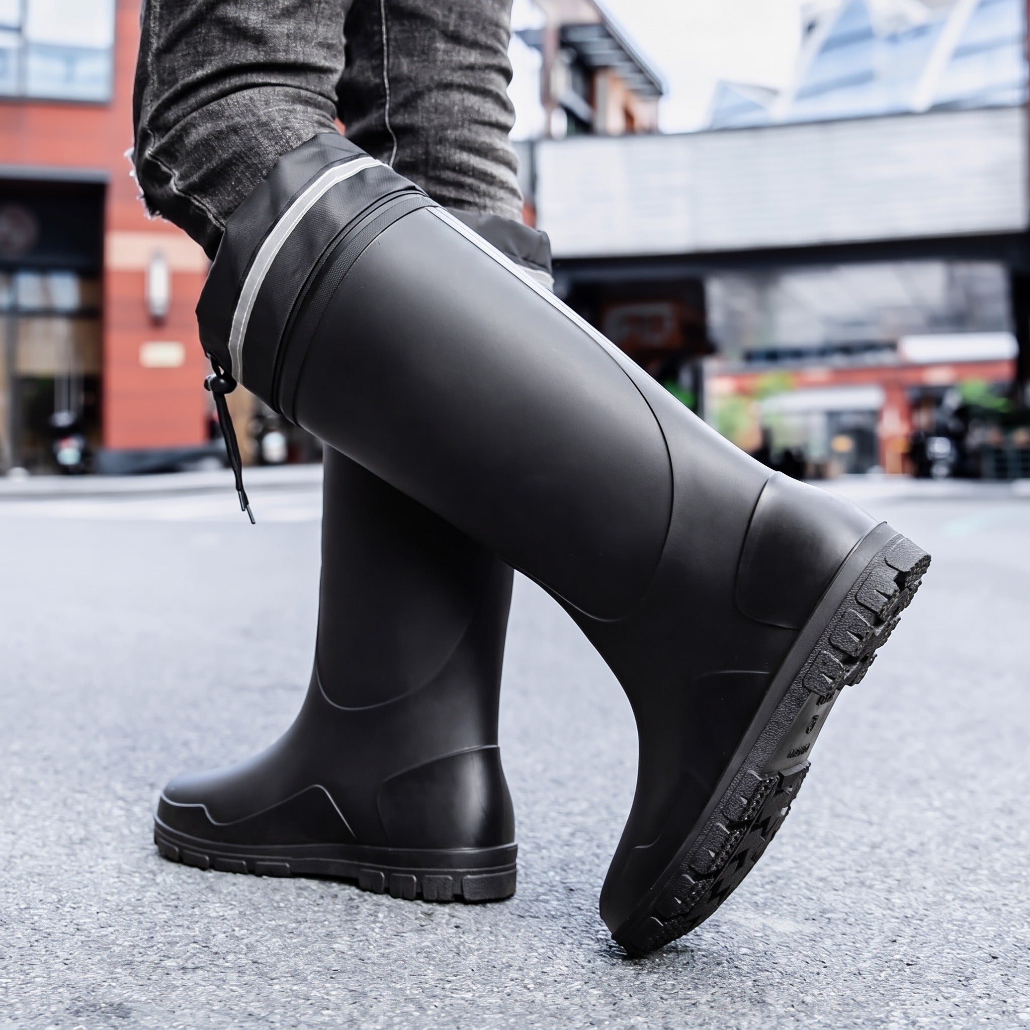 Black knee-high rubber boots with lug sole worn by person standing | Chaps London