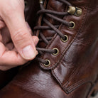 Hands lacing brown eyelet boot, close-up view, worn by person | Chaps London