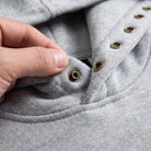 Close-up of grey hoodie showing brass snap buttons on neckline | Chaps London