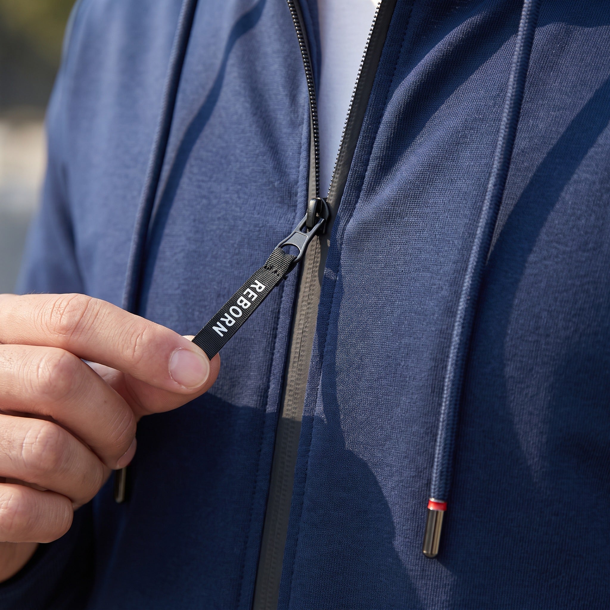 Navy zip-up hooded tracksuit top with red stripe drawstrings, worn by person | Chaps London