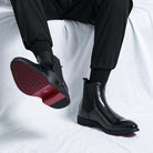 Black Chelsea boot worn on foot, showing red and black textured sole | Chaps London