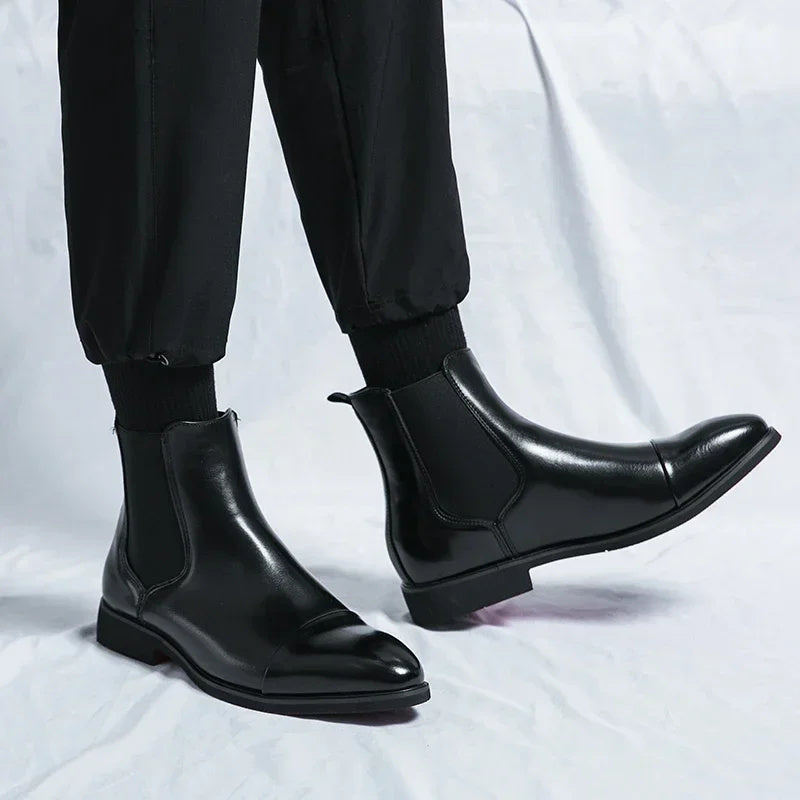 Black faux leather Chelsea boots worn on feet, pull-tab slip-on design | Chaps London
