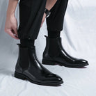Black faux leather Chelsea boots worn by person, slip-on style, cuffed pants | Chaps London