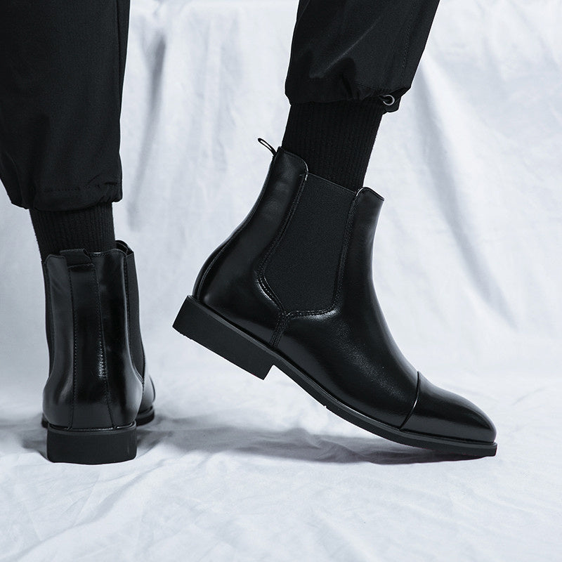 Black faux leather Chelsea boots with pull tabs, worn by a person | Chaps London