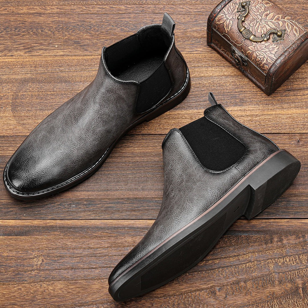 Gray leather Chelsea ankle boots with elastic side panels, displayed flat on wood | Chaps London