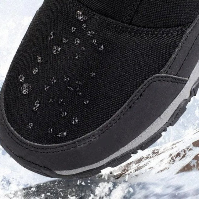 Black fabric snow boot close-up with water droplets on toe area | Chaps London
