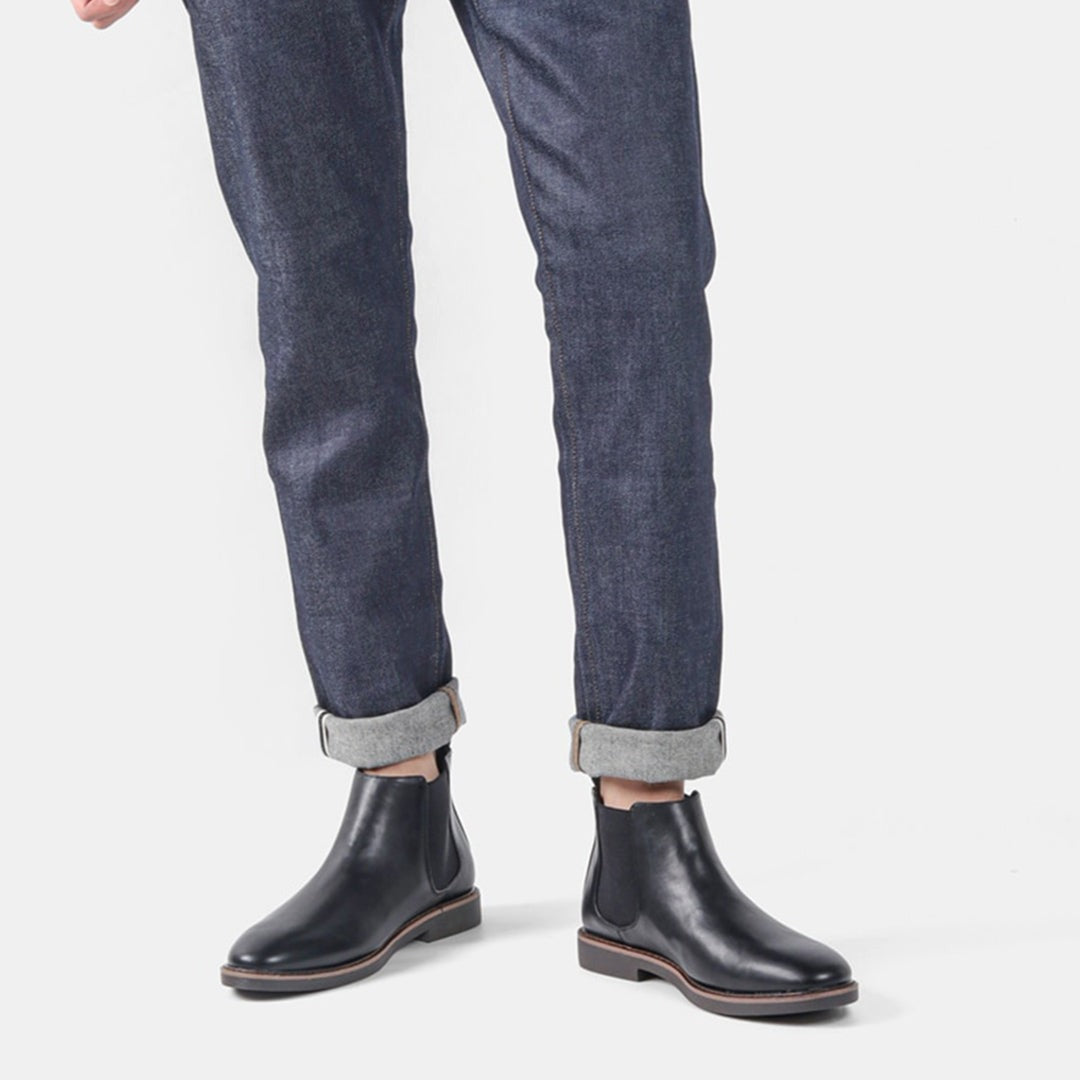 Black leather Chelsea boots worn by man in cuffed raw denim jeans | Chaps London