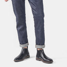 Black leather Chelsea boots worn by man in cuffed raw denim jeans | Chaps London