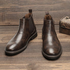 Brown leather Chelsea ankle boots with elastic side panels, displayed flat on wood | Chaps London
