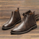 Brown leather Chelsea boots with elastic side panels, displayed flat on wood | Chaps London