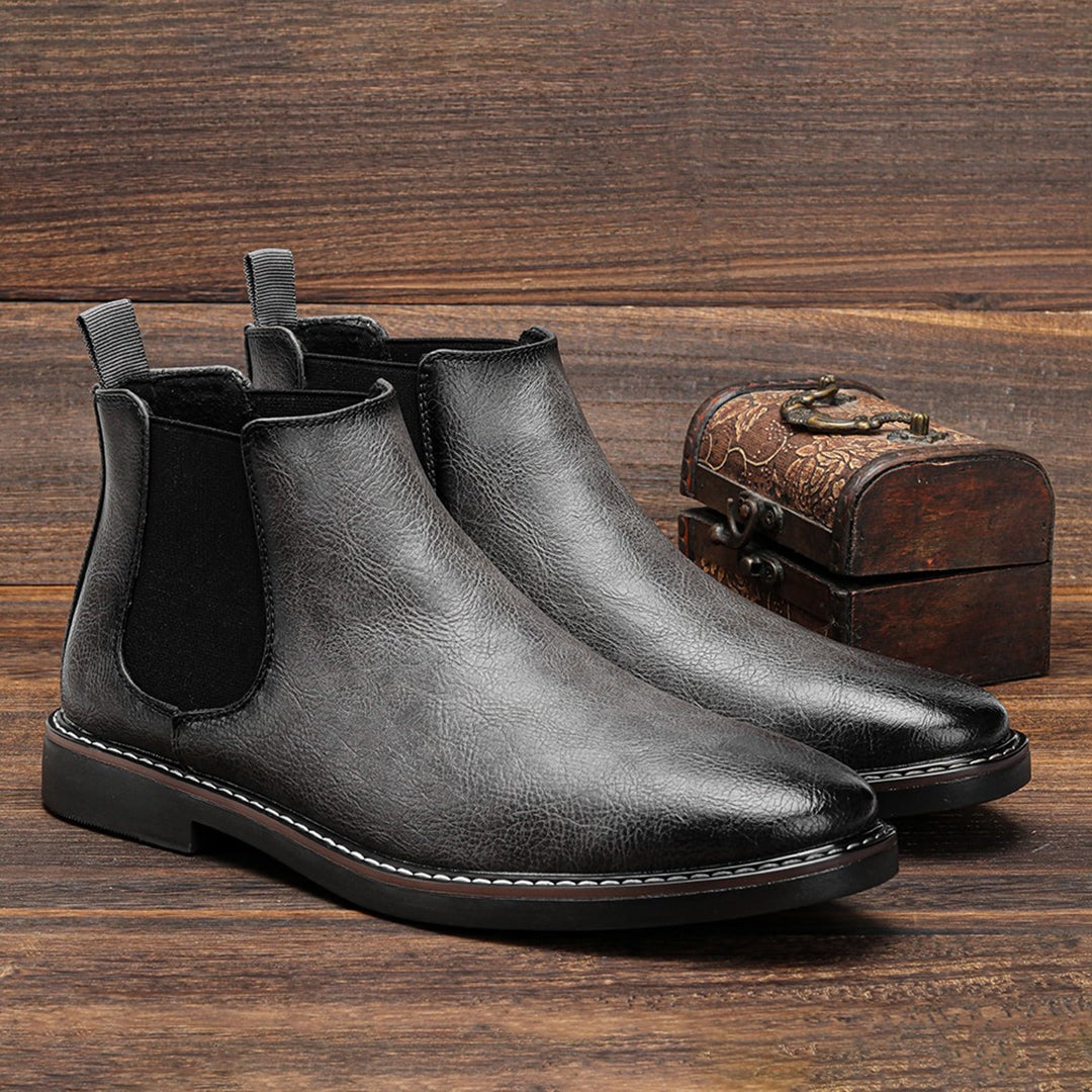 Gray leather Chelsea ankle boots with elastic side panels, displayed on wooden surface | Chaps London