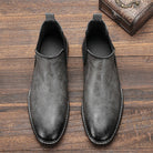 Gray leather Chelsea boots with stitched detail, shown flat on wood | Chaps London