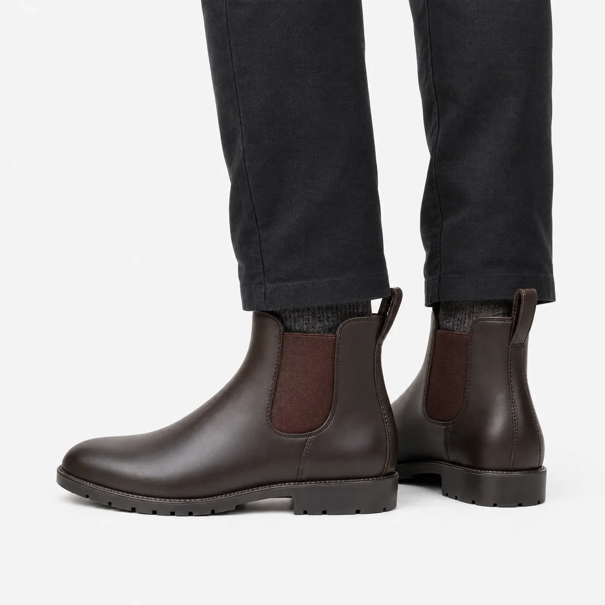 Brown Chelsea wellies with dark grey trousers, side view