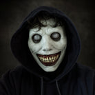 White demon mask with hollow eyes and grinning teeth, worn by person | Chaps London