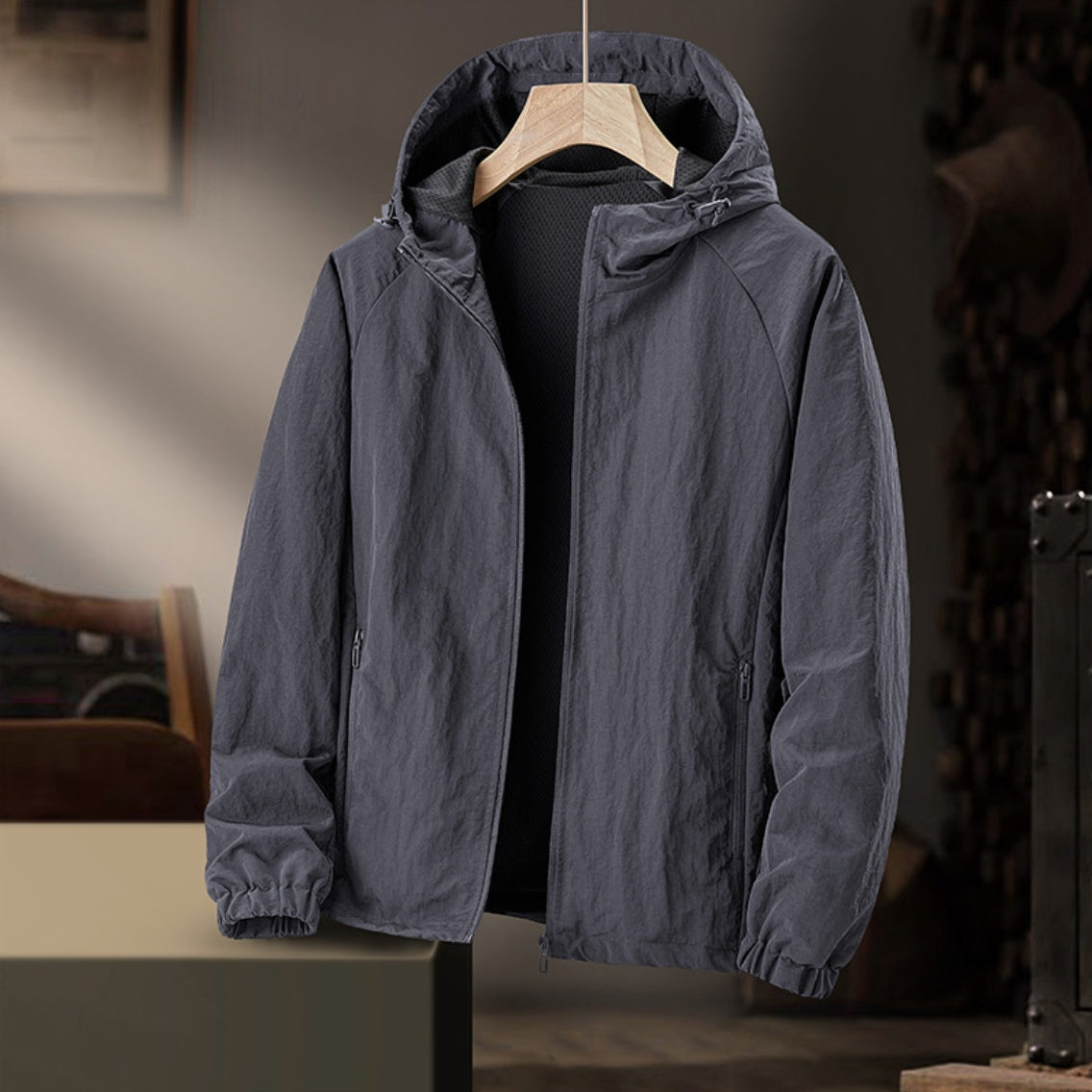 Gray hooded windbreaker jacket on hanger, zipped front, indoor setting | Chaps London