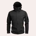 Black hooded softshell jacket with zip pockets, worn by a person | Chaps London