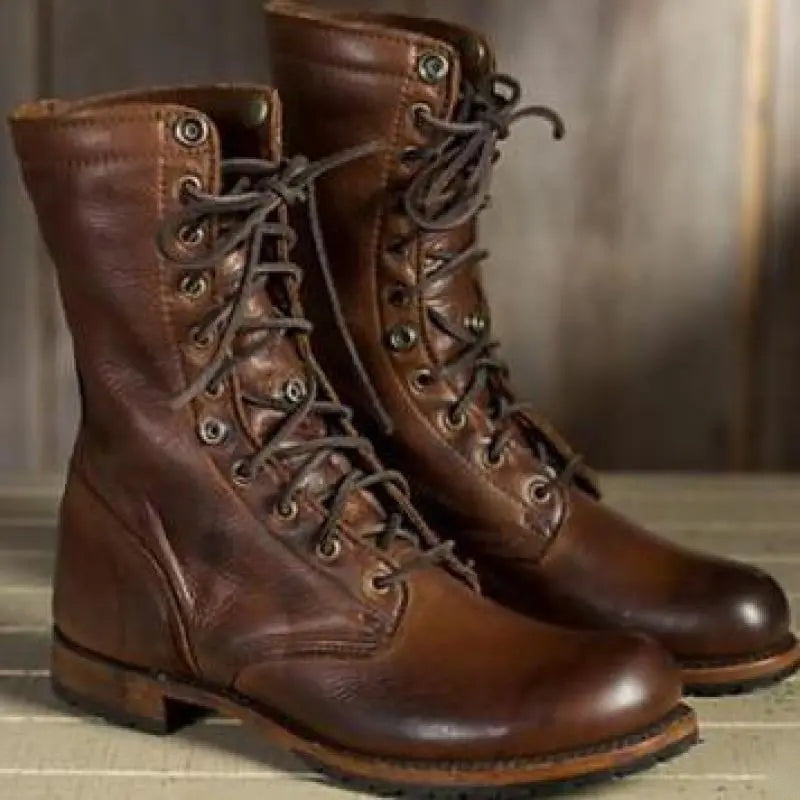 Brown lace-up boots worn by a person, outdoor wooden background | Chaps London