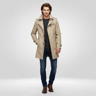 Man wearing beige trench coat, grey sweater, jeans, and brown boots | Chaps London