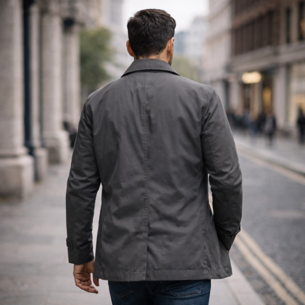 Man wearing gray button-front rain mac walking on city street | Chaps London