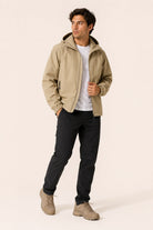 Man wearing beige hooded jacket, white t-shirt, black pants, and boots | Chaps London