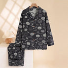 Black pyjama set with pumpkin and candy print, hanging on hanger | Chaps London