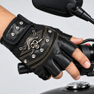 Black fingerless biker glove with skull emblem, rivets, worn on hand gripping handlebar | Chaps London