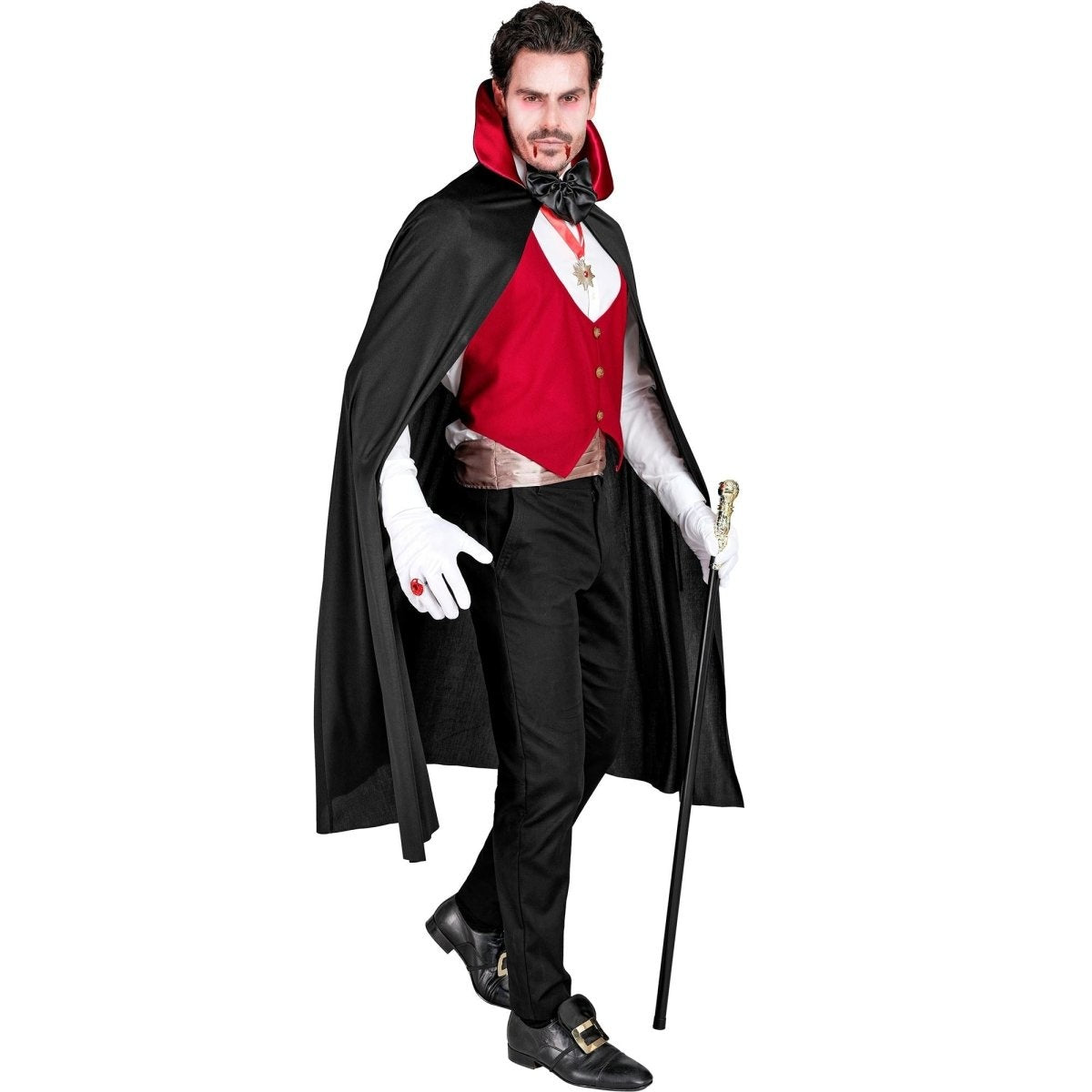 Man wearing black vampire cape with red waistcoat and bow tie, holding cane | Chaps London