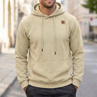 Beige quilted hoodie with chest patch, worn by man outdoors | Chaps London