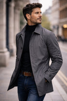 Man wearing gray rain mac with black turtleneck and jeans outdoors | Chaps London