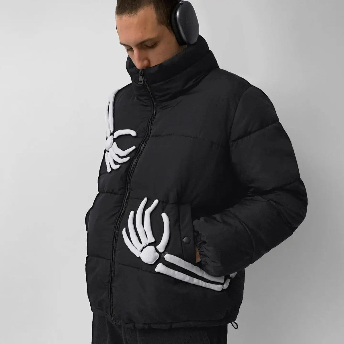 Man wearing black puffer jacket with white skeleton hand graphic design | Chaps London