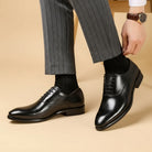 Black lace-up Oxford dress shoes worn with striped trousers and dark socks | Chaps London