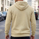 Beige quilted-texture hoodie worn by man, back view, outdoor street setting | Chaps London