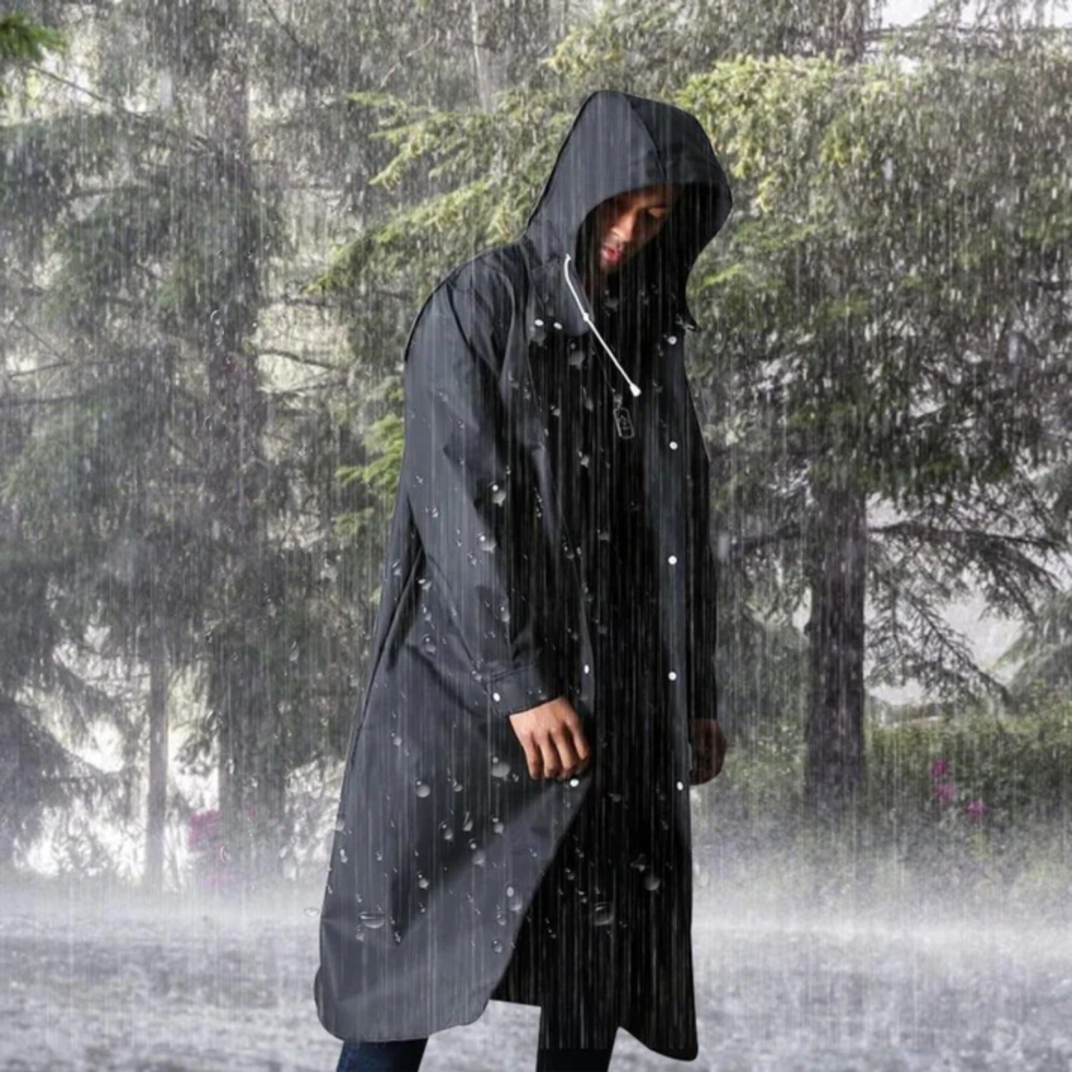 Man wearing black hooded waterproof raincoat standing outdoors in heavy rain | Chaps London