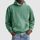 Man wearing green washed oversized hoodie with kangaroo pocket, paired with jeans | Chaps London