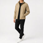 Man wearing beige zip-up jacket, black t-shirt, black pants, white sneakers | Chaps London