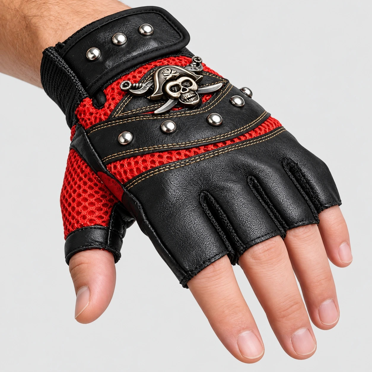Black and red fingerless glove with skull emblem and rivets, worn on hand | Chaps London