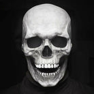 White skull mask with movable jaw worn by person, black background | Chaps London