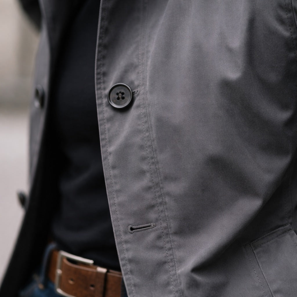 Gray cotton rain mac button detail worn by person, close-up view | Chaps London
