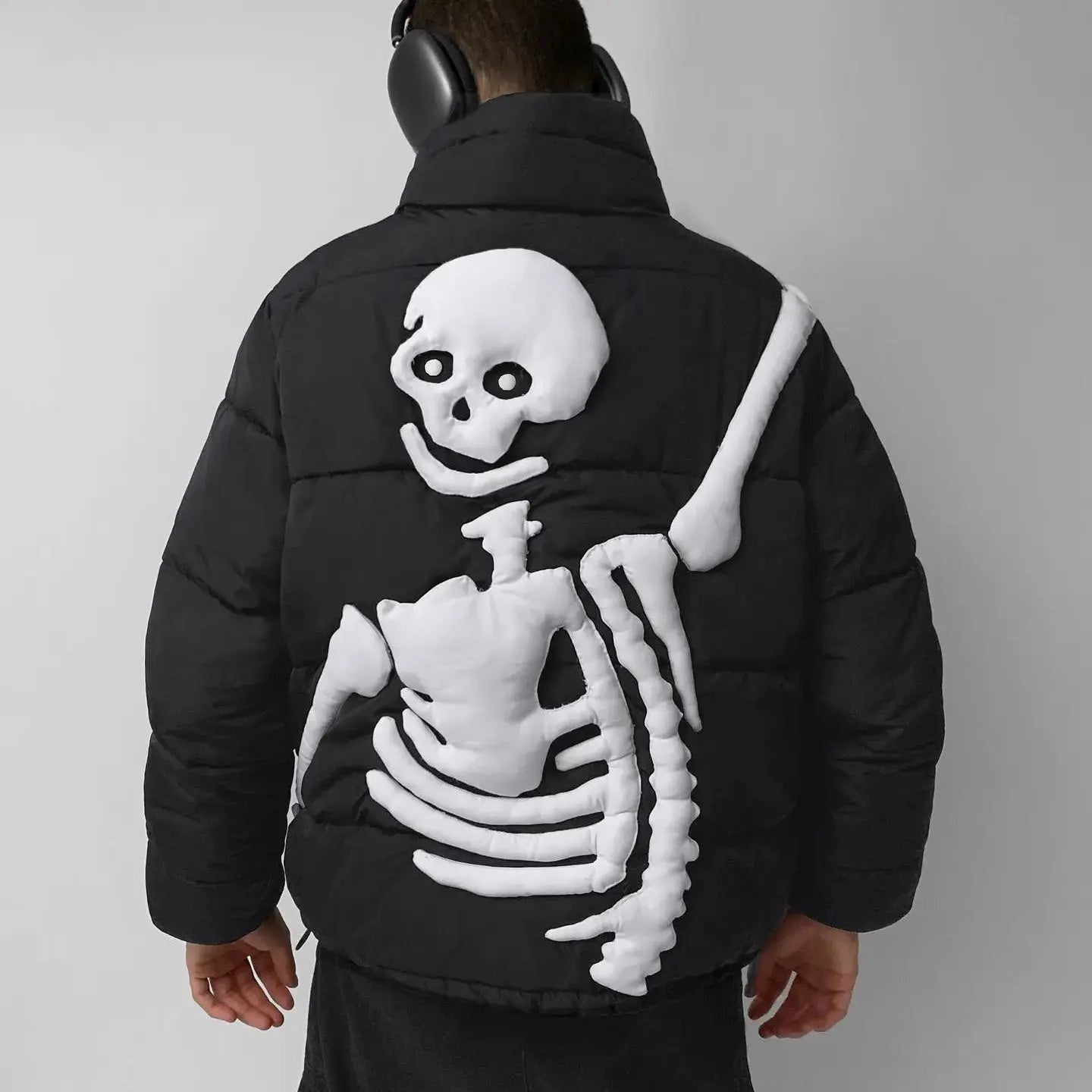 Black puffer jacket worn by man, white skeleton design on back | Chaps London