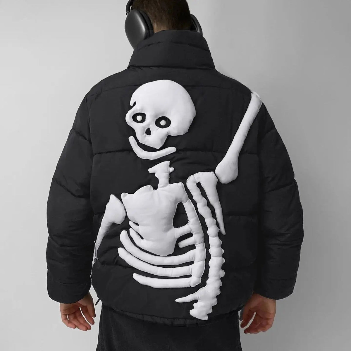 Black puffer jacket worn by man, white skeleton design on back | Chaps London