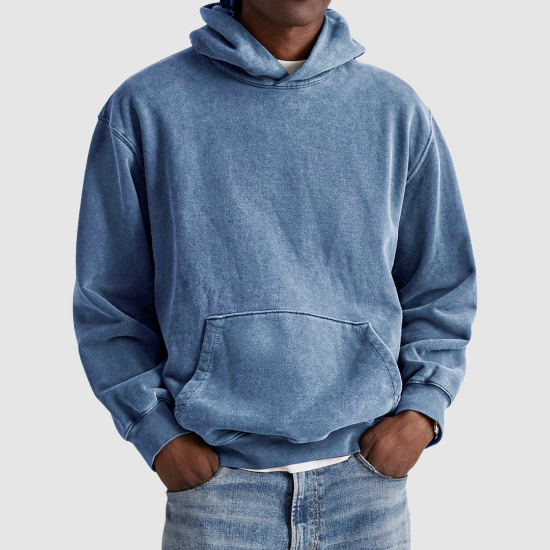 Man wearing oversized washed blue hoodie with kangaroo pocket, paired with jeans | Chaps London